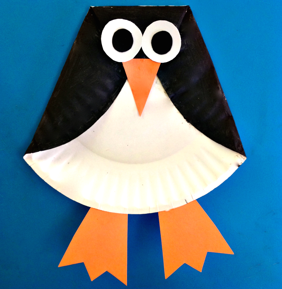 Penguin made out of a paper plate on a blue background.